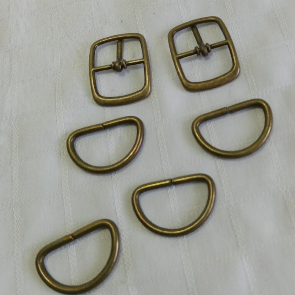 J-  Two original bronze-colored handbag or watch clips and four rings